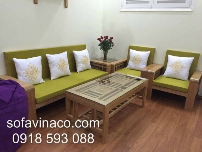 Đệm ghế xanh lá đi kèm với gối hoa trắng làm không gian phòng khách tươi mới hơn