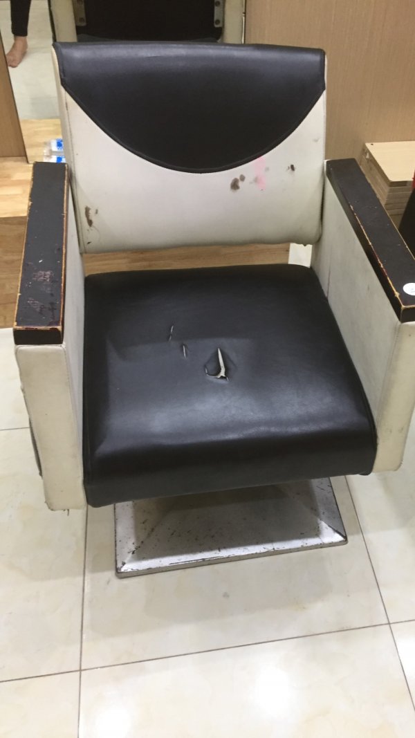 Mặt ngồi của chiếc ghế cắt tóc này bị kéo đâm rách