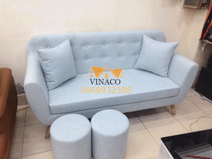 Chiếc ghế sofa đơn được chia ô, múi rõ ràng và hai chiếc đôn tròn