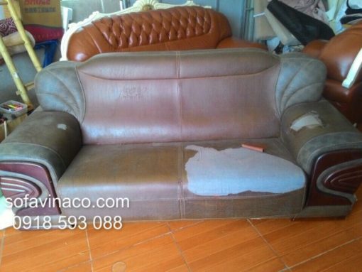 Bộ ghế sofa có vỏ bọc đã cũ rách và bạc màu