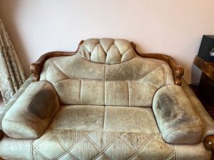 Chiếc ghế sofa da hai chỗ bị mốc và bám bẩn