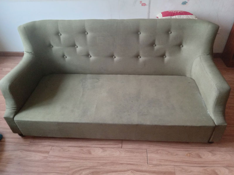 Chiếc ghế sofa vải cũ bẩn và bị mất cúc của khách hàng ở Lê Quang Đạo